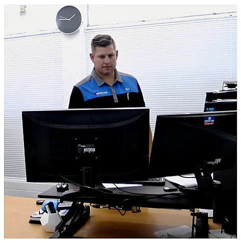 Ross Strybos, principal electrician, working at his desk in the Strybos office